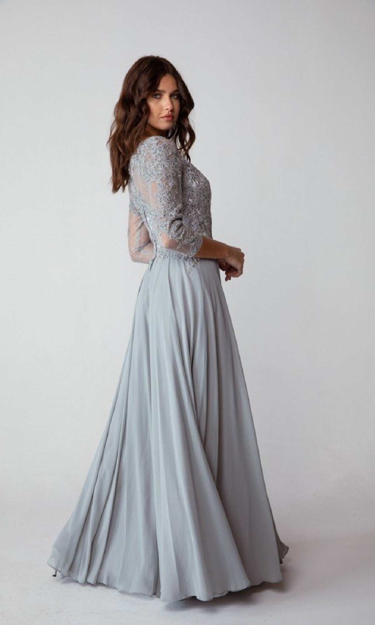 A woman models the Eureka 6909 Long-Sleeve Long Formal Dress in light gray, featuring a lace bodice and modest A-line silhouette, against a plain white background.